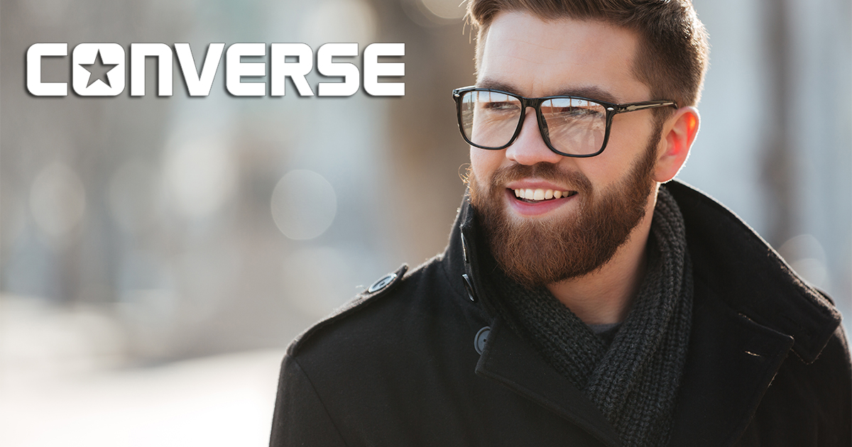 Portrait of happy bearded young man in glasses standing outdoors in winter