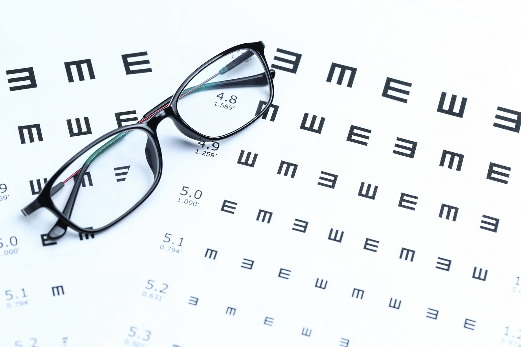 Glasses and eye chart on white background Glasses and eye chart on white background