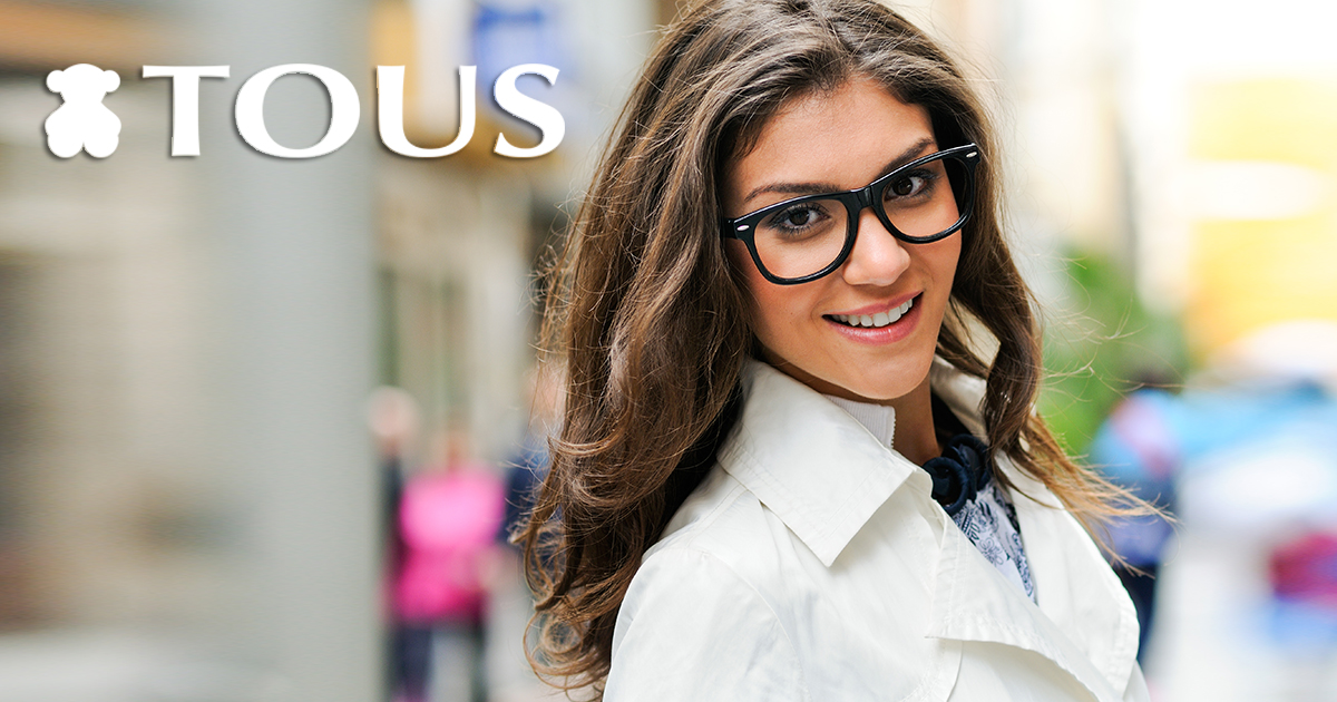 Portrait of a beautiful woman with eye glasses smiling in urban background